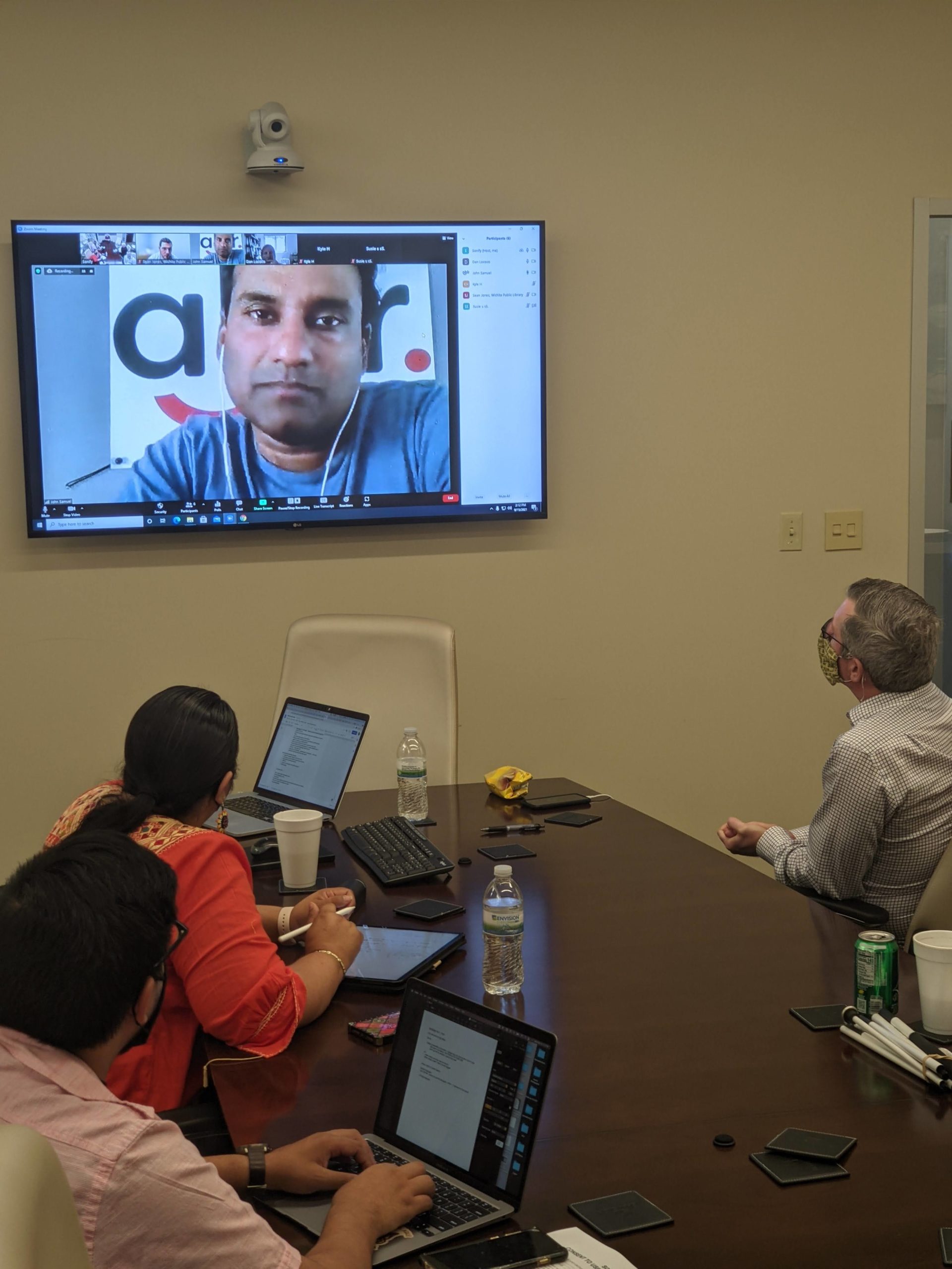 People in conference room looking at digital screen